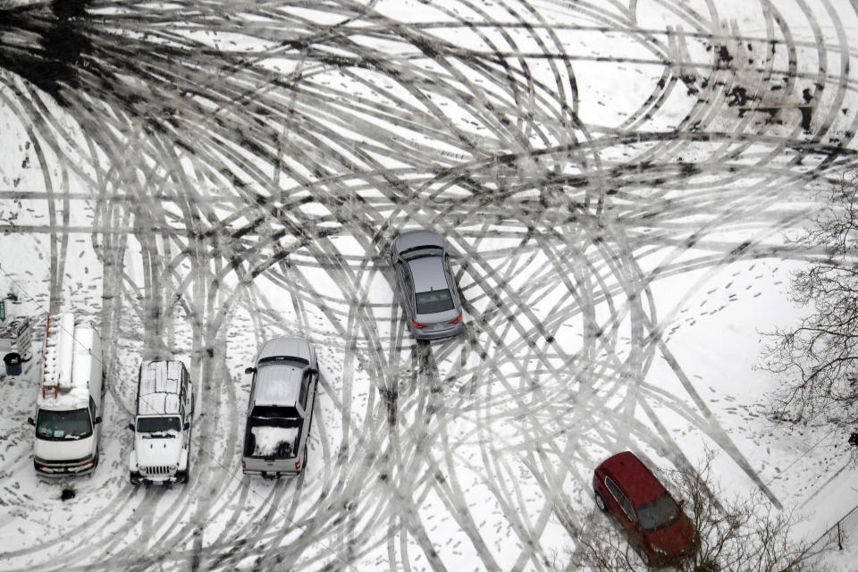 FILE - In this Feb. 11, 2019, file photo a car maneuvers through a still snow-covered parking lot in Seattle. With the eastern two-thirds of the U.S. shivering through an early blast of arctic air, it’s time to start thinking about whether your car’s tires will get you safely through the winter. (AP Photo/Elaine Thompson, File)