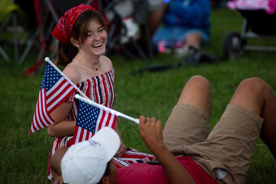 Ashleigh Merritt waves an American Flag during the Fourth of July concert and fireworks display at Pat and Lou Sisbarro Community Park on the New Mexico State University campus in Las Cruces on Monday, July 4, 2022.