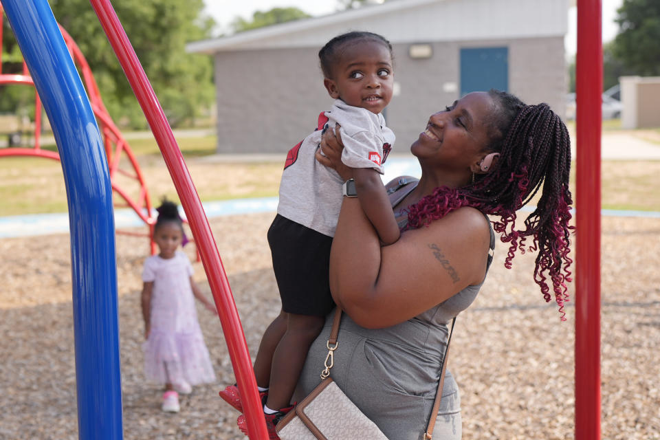 Tamika Davis, right, spends time with her children, Lionel Jr., 2, centers and Shanara, 3, left at MLK Park in San Antonio, Thursday, May 30, 2024. Davis said friends and family watched her kids for most of her doctor visits during treatment last year for colon cancer. But she couldn't afford additional childcare, and she didn't know where to look for assistance. (AP Photo/Eric Gay)