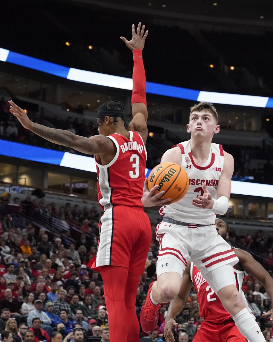 Wisconsin's Connor Essegian drives to the basket past Ohio State's Eugene Brown III during the second half of an NCAA college basketball game at the Big Ten men's tournament, Wednesday, March 8, 2023, in Chicago. Ohio State won 65-57. (AP Photo/Charles Rex Arbogast)