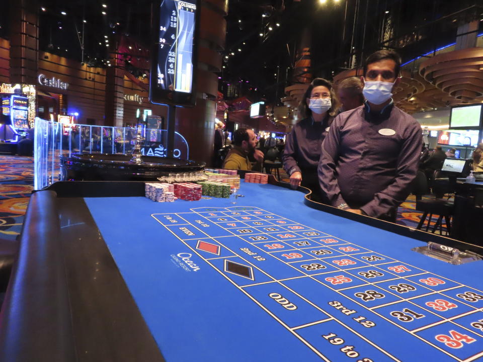 Roulette dealers wearing face masks at the Ocean Casino Resort in Atlantic City, N.J. wait for customers on Dec. 2, 2022. The New Jersey Supreme Court is expected to hear arguments, Wednesday, Sept. 27, 2023, in a case involving whether insurance companies were correct in denying payouts to the casino for business losses during the state-mandated closure in 2020. (AP Photo/Wayne Parry)