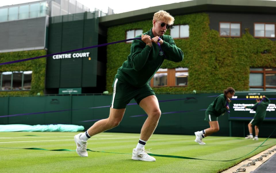 Ground staff pull out the rain covers during day three of The Championships Wimbledon 2023 at All England Lawn Tennis and Croquet Club on July 05, 2023 in London, England