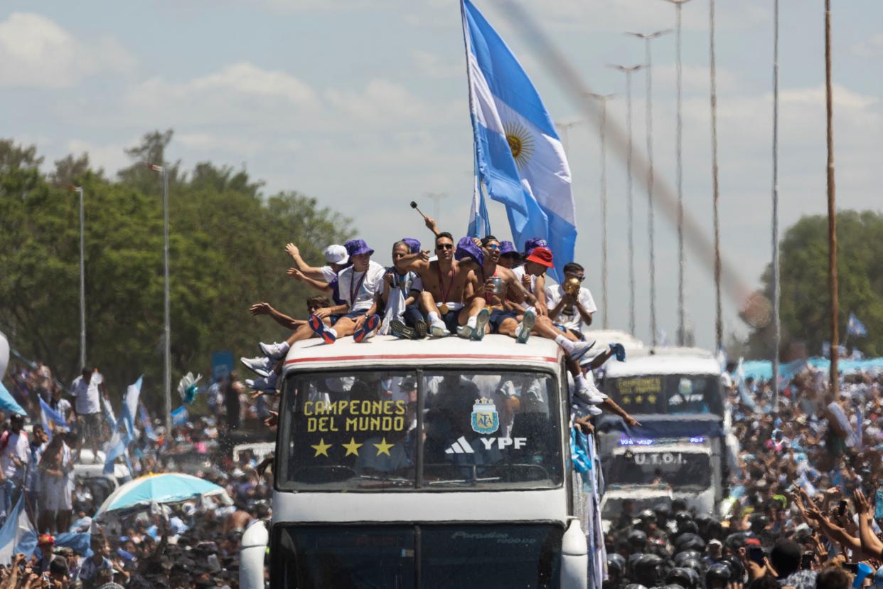 Argentina's players celebrate on board a bus with a sign reading 