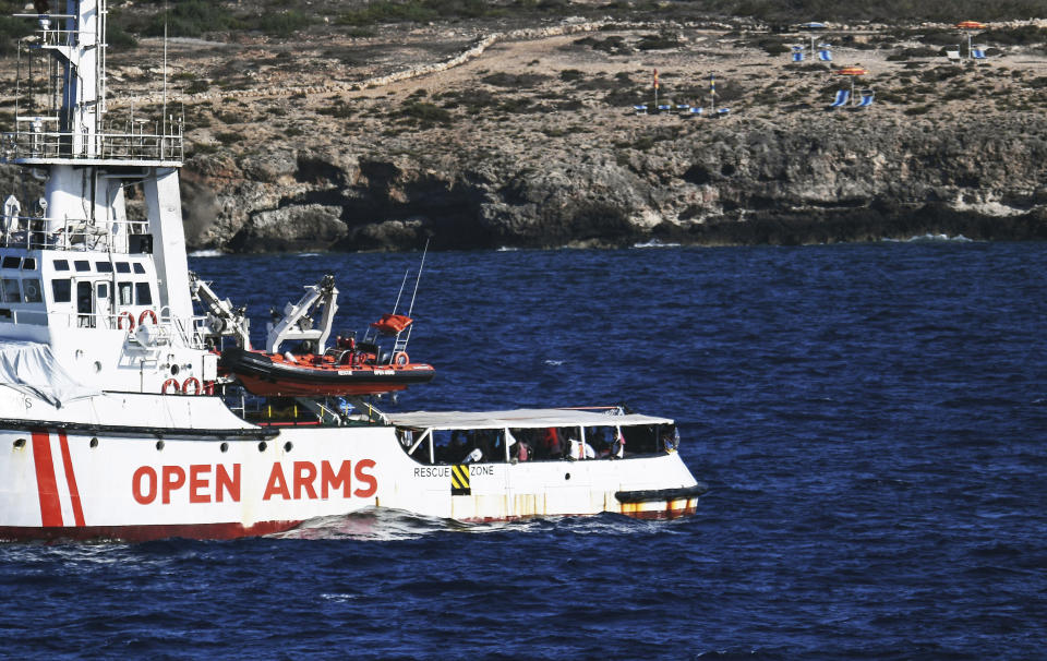 The Open Arms vessel with 107 migrants on board is anchored off the Sicilian vacation and fishing island of Lampedusa, southern Italy, Monday, Aug. 19, 2019. Open Arms on Monday suggested chartering a plane to fly to Spain the migrants blocked off the coast of Italy aboard its boat since early August, to end a stalemate with the Italian Interior minister Matteo Salvini, who won't let private rescue boats into his nation's ports. (AP Photo/Salvatore Cavalli)