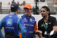 Jimmie Johnson, left, talks with Scott Dixon, of New Zealand, and Dario Franchitti during qualifications for the Indianapolis 500 auto race at Indianapolis Motor Speedway, Saturday, May 21, 2022, in Indianapolis. (AP Photo/Darron Cummings)