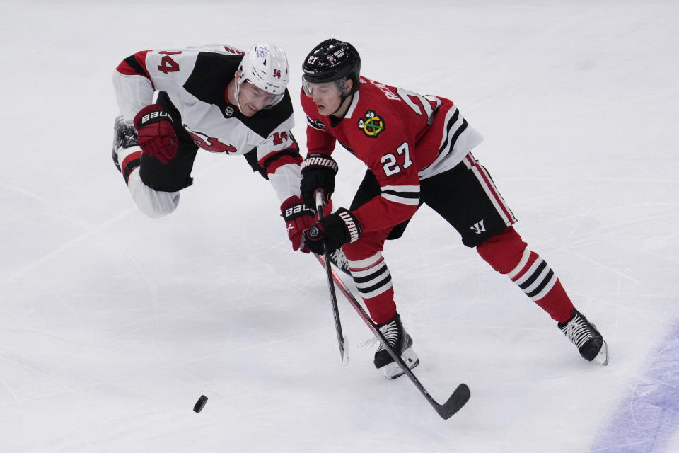 New Jersey Devils right wing Nathan Bastian, left, and Chicago Blackhawks left wing Lukas Reichel, right, battle for the puck during the first period of an NHL hockey game in Chicago, Sunday, Nov. 5, 2023. (AP Photo/Nam Y. Huh)