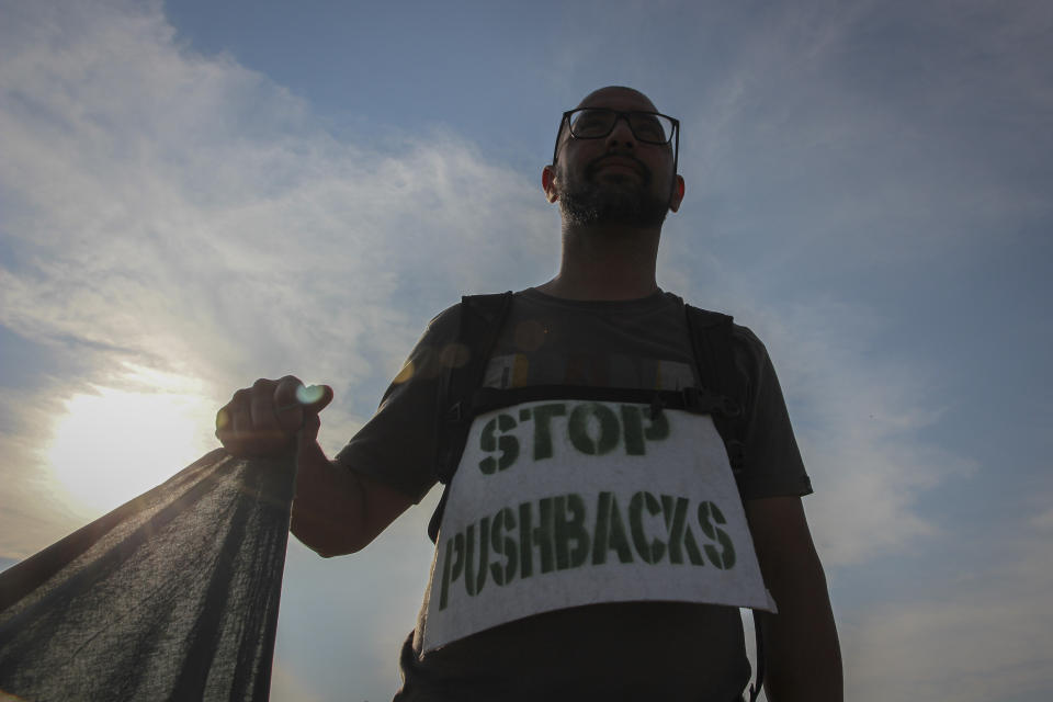 A man holds a banner during a protest against the violent pushbacks of migrants, allegedly conducted by Croatian police, near the border crossing between Croatia and Bosnia Herzegovina in Maljevac, Croatia, Saturday, June 19, 2021. More than one hundred members of human rights NGO's, mostly from Italy, but also from Germany, Austria, Spain and Slovenia blocked the border traffic for about two hours protesting demanding a stop of all deportation of migrants, and cancellation of EU's Frontex operations at borders, preventing migrants from traveling. (AP Photo/Edo Zulic)