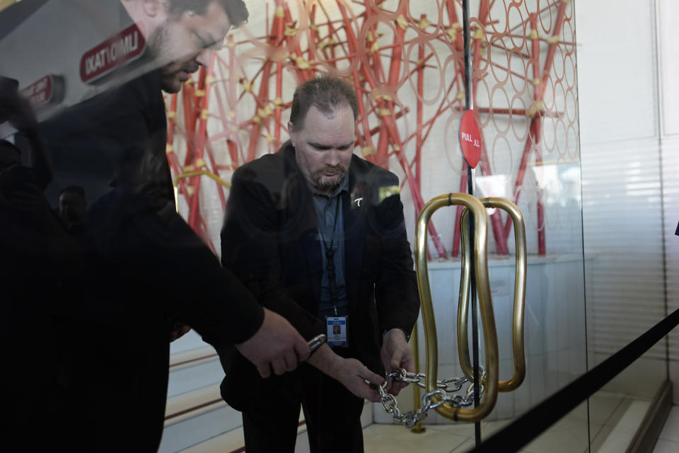 Tropicana security chain up the doors after the closing of the historic property at the Tropicana hotel-casino, Tuesday, April 2, 2024, in Las Vegas. The hotel-casino is slated for demolition in October to make room for a $1.5 billion baseball stadium. (AP Photo/John Locher)