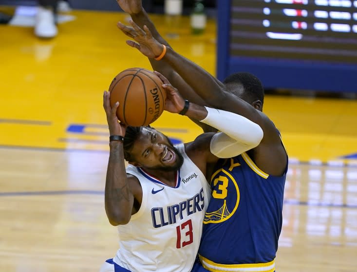 Los Angeles Clippers guard Paul George (13) reacts as he is fouled by Golden State Warriors forward Draymond Green (23) during the first half of an NBA basketball game in San Francisco, Friday, Jan. 8, 2021. (AP Photo/Tony Avelar)