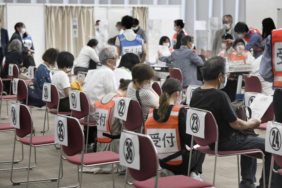 People wait to be processed after arriving to receive the Moderna coronavirus vaccine at the newly-opened mass vaccination center in Osaka, western Japan, Monday, May 24, 2021. Japan mobilized military doctors and nurses to give shots to elderly people in Tokyo and Osaka on Monday as the government desperately tries to accelerate its vaccination rollout and curb coronavirus infections just two months before hosting the Olympics. (Kyodo News via AP)