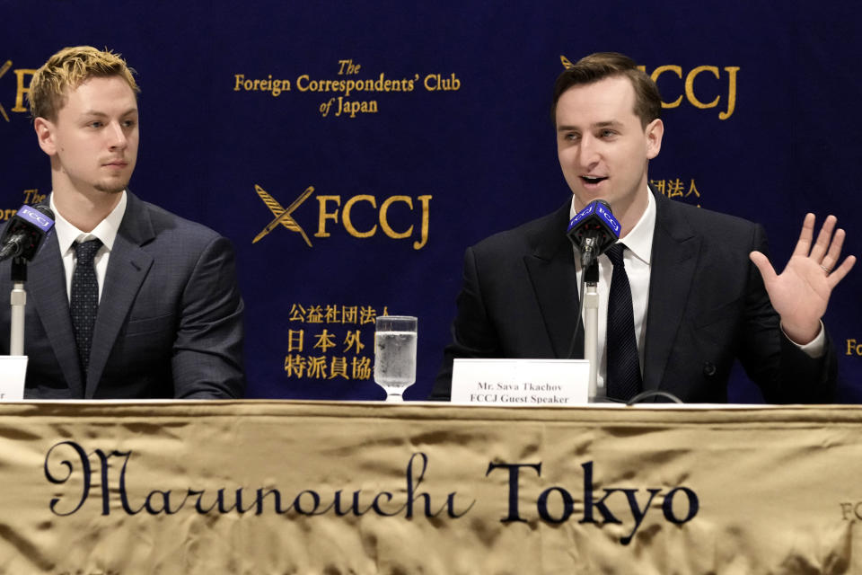 Ukraine's YouTubers, Sava Tkachov, right, speaks as his young brother Yan Tkachov listens to a press conference at the Foreign Correspondents Club of Japan in Tokyo, Thursday, March 31, 2022. The Ukrainian YouTuber duo Sawayan, popular among young Japanese for their funny videos and chat over Mario Kart games, are now using their platform to share the reality of war in Ukraine and send an antiwar message. (AP Photo/Shuji Kajiyama)