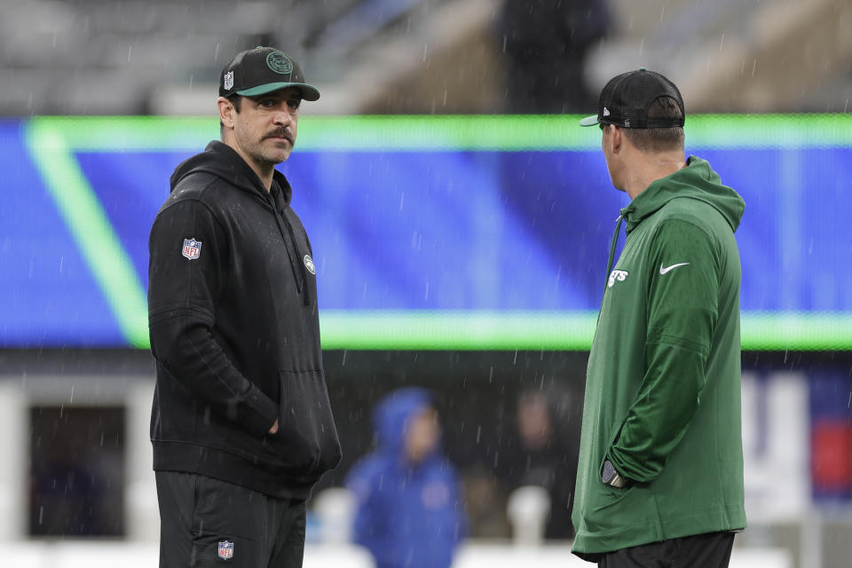 New York Jets quarterback Aaron Rodgers, left, and quarterback Zach Wilson, right, attend practice in the rain before an NFL football game against the New York Giants, Sunday, Oct. 29, 2023, in East Rutherford, N.J. (AP Photo/Adam Hunger)