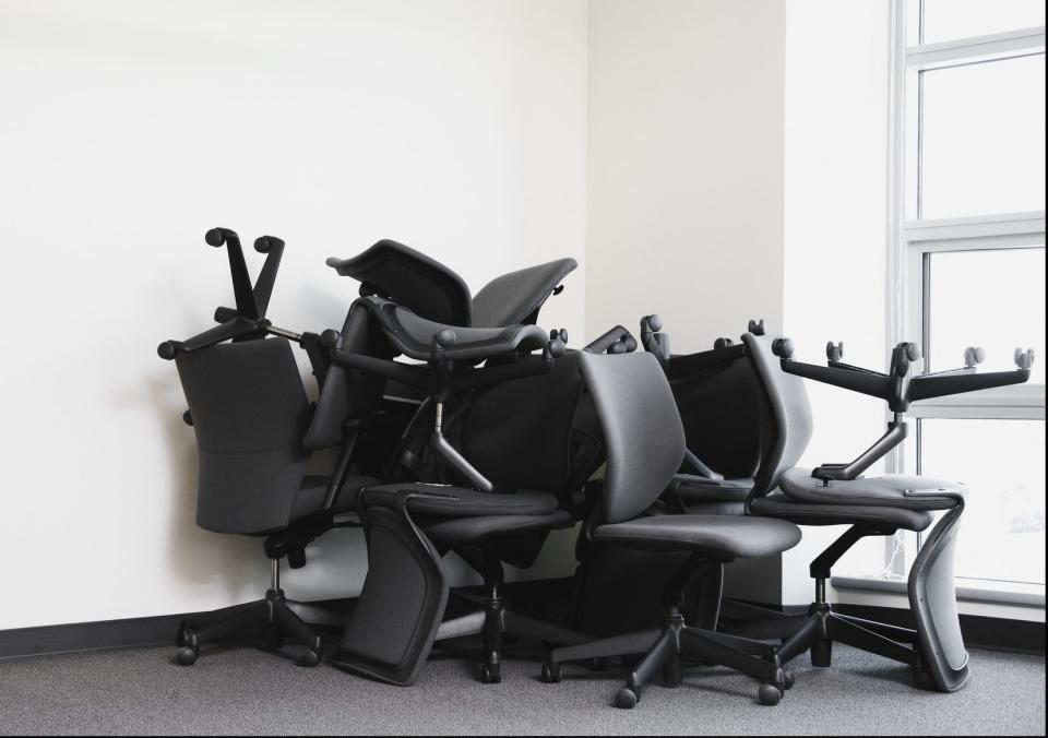 Office chairs piled in corner of empty office