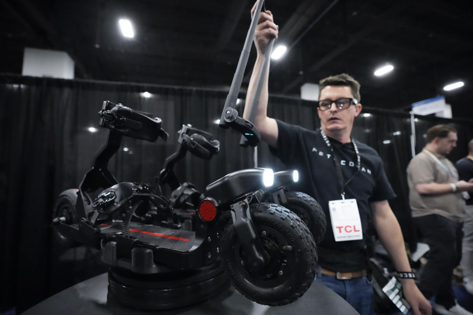 An attendee looks at the SKWheel electric ski during CES Unveiled before the start of the CES tech show Sunday, Jan. 7, 2024, in Las Vegas. (AP Photo/Ryan Sun)
