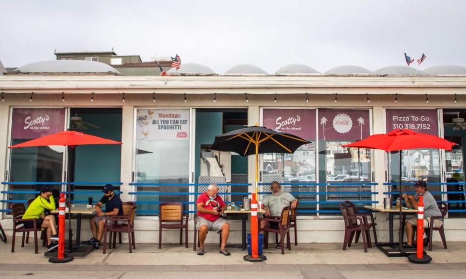 People sit outside a restaurant and bar in Hermosa Beach, Los Angeles, California, 14 July 2020.