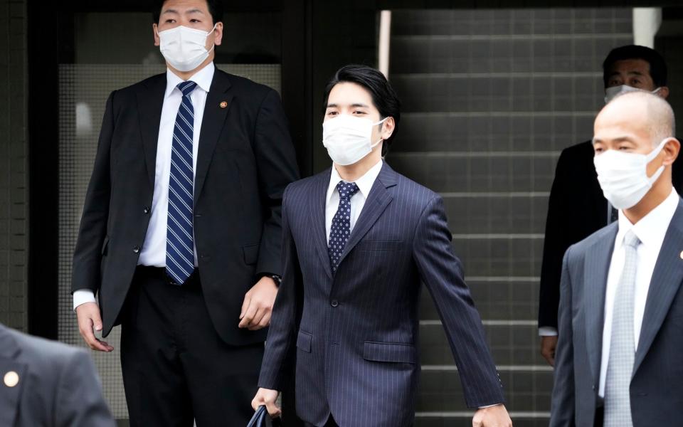 Kei Komuro said nothing to the camera crews outside his house as he left for the ceremony - GETTY IMAGES