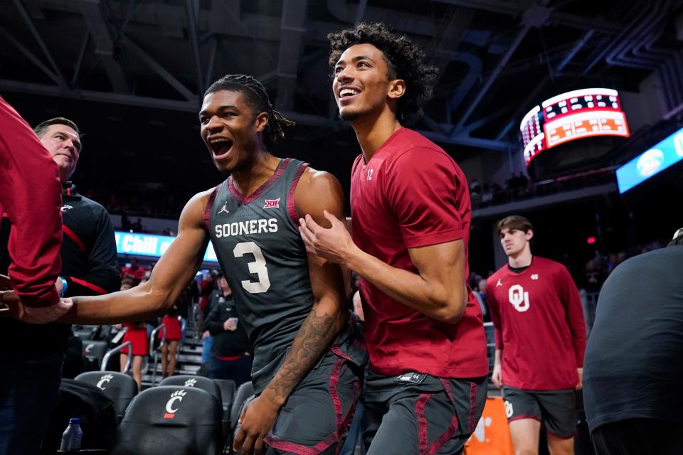 OU guards Otega Oweh, left, and Milos Uzan, right, run onto the court before a win at Cincinnati on Jan. 20.