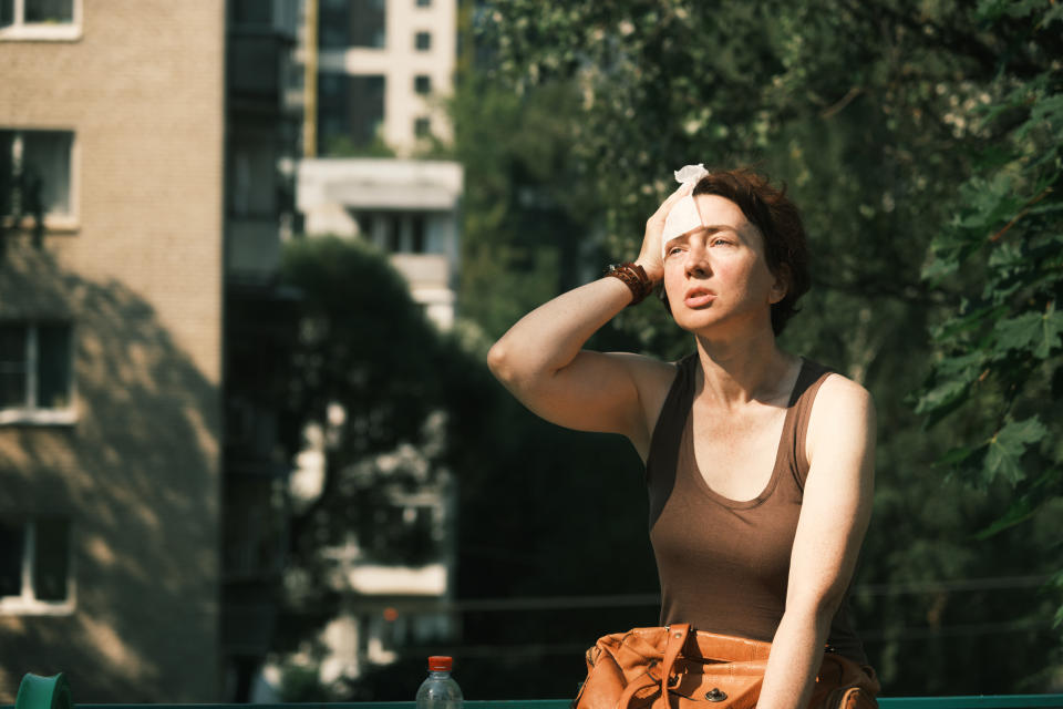 Mature woman is feeling bad during the heat wave in city