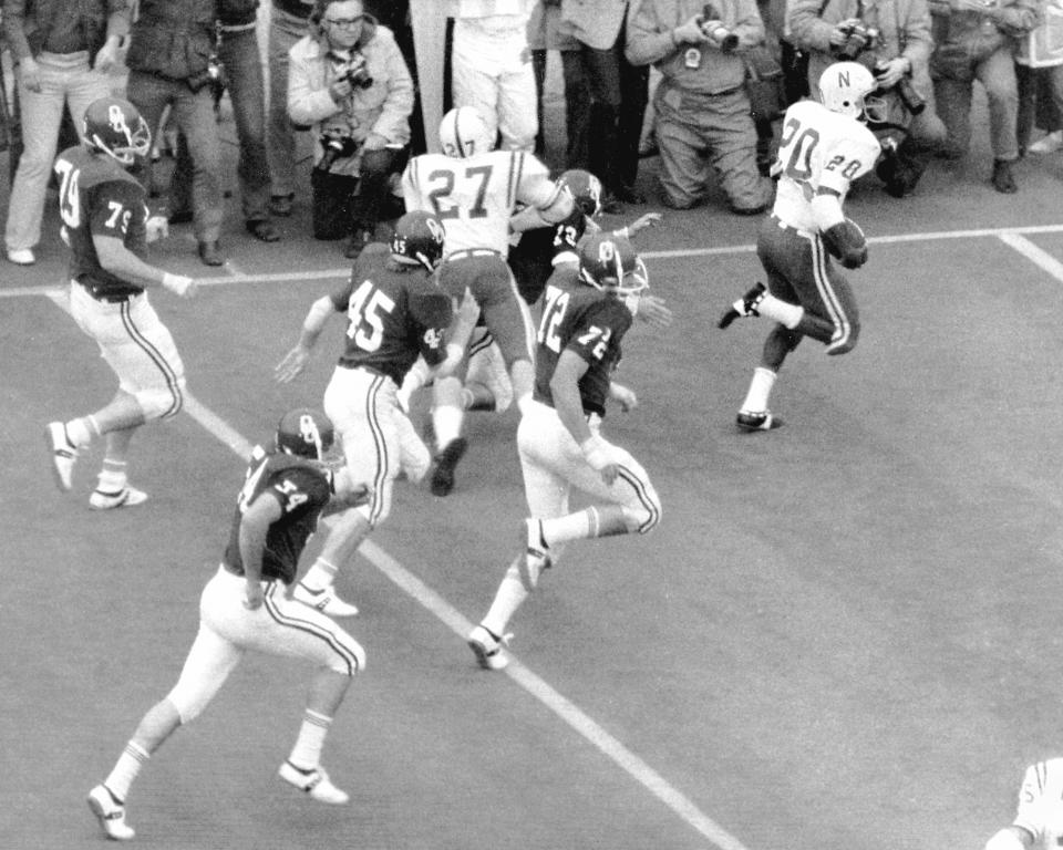 FILE - In this Thanksgiving Day 1971 file photo, Nebraska's Johnny Rodgers (20) returns a punt for a touchdown as teammate Joe Blahak (27) delivers a block in the first quarter of an NCAA college football game against Oklahoma, in Norman, Okla. The game, which Nebraska won 35-31, is widely remembered as "The Game of the Century." Fifty years later, Rodgers still gets asked about the play. (Bob Gorham/Lincoln Journal Star via AP, File)