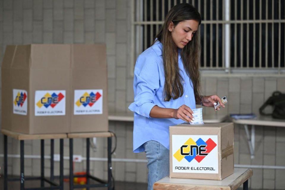 Ciudadana venezolana ingresa el boleto impreso con su voto el domingo 28 de julio.
