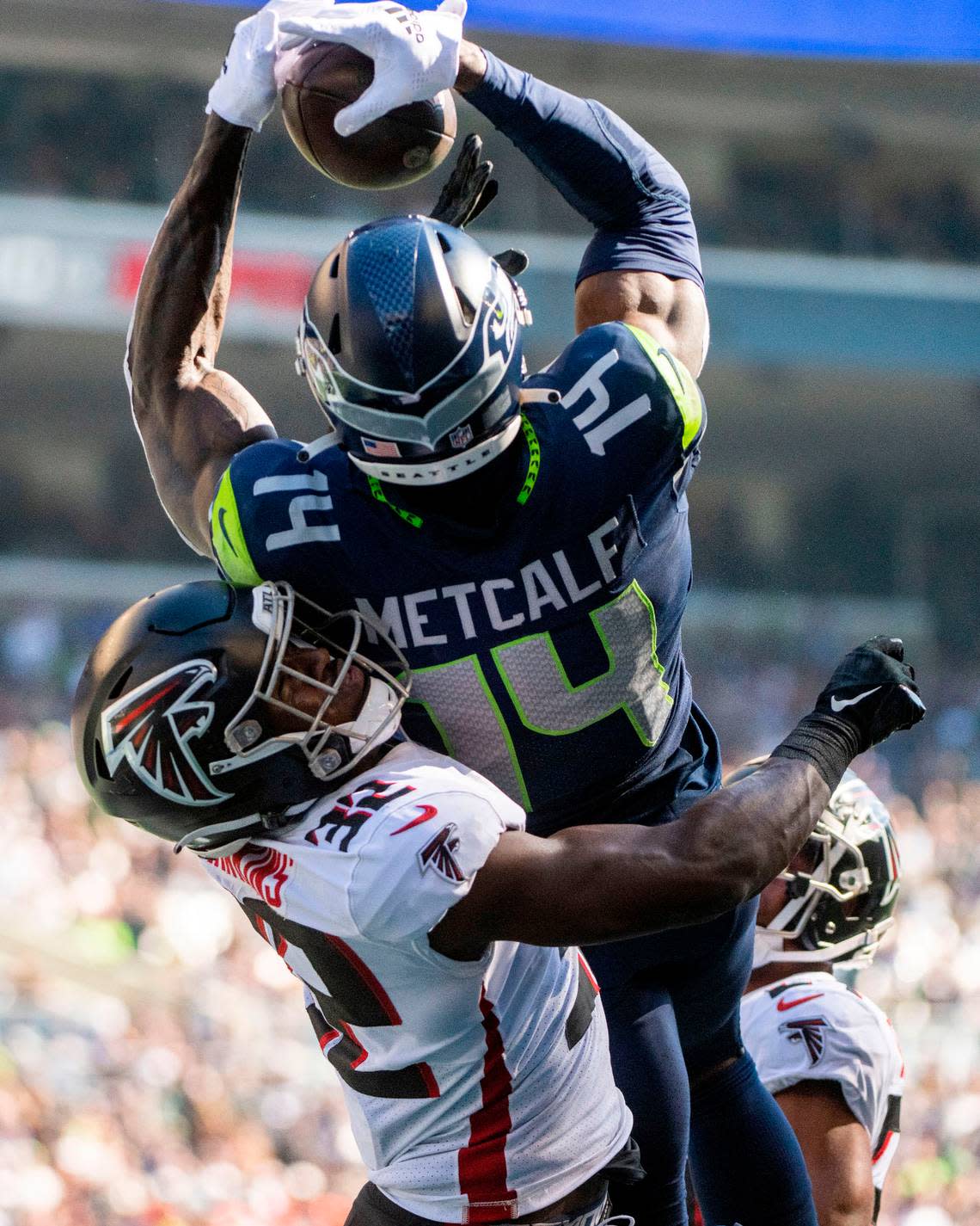 Seattle Seahawks wide receiver DK Metcalf (14) catches a pass from quarterback Geno Smith (7) in the endzone as Atlanta Falcons safety Jaylinn Hawkins (32) defends during the second quarter of an NFL game on Sunday, Sept. 25, 2022, at Lumen Field in Seattle.