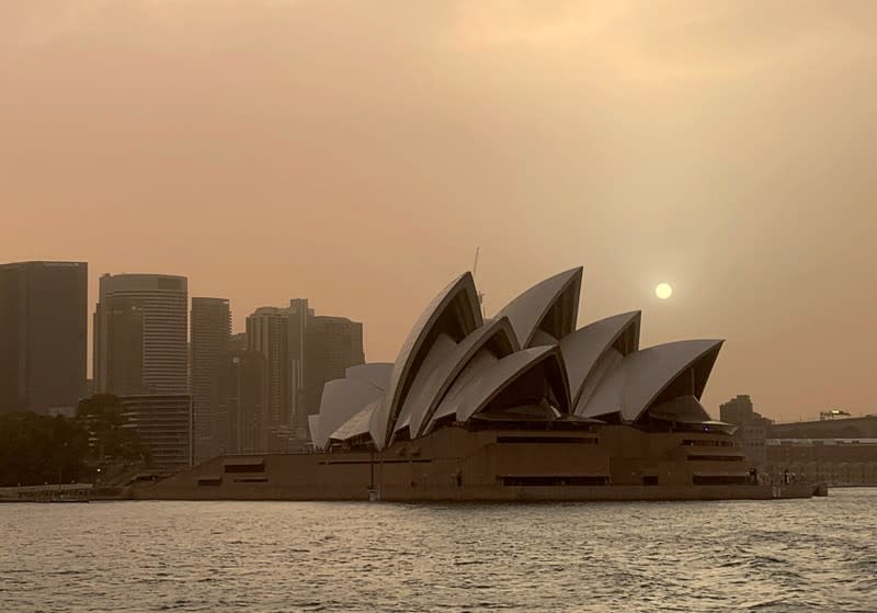 The moon rises over the Sydney Opera House as smoke from bushfires shrouds the skyline in Sydney