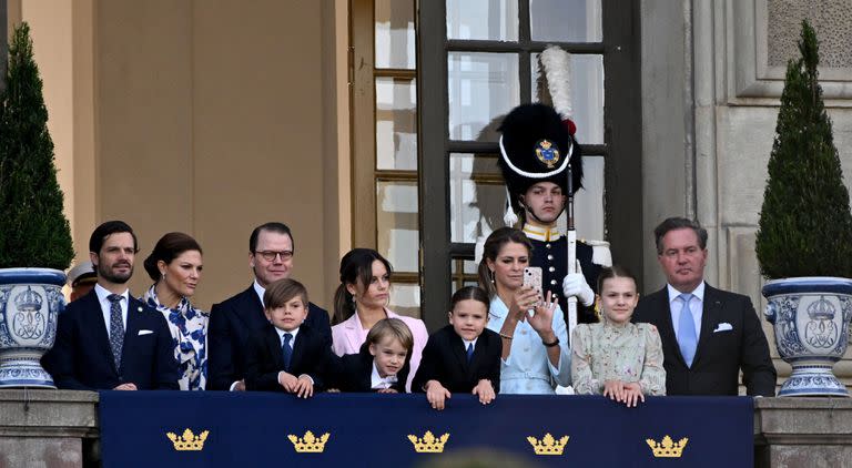 El príncipe Carlos Felipe de Suecia, la princesa heredera Victoria de Suecia, el príncipe Daniel de Suecia, la princesa Sofía de Suecia, la princesa Madeleine de Suecia y Christopher O'Neill se encuentran en el balcón del palacio durante las festividades para celebrar el 50º aniversario del rey Carlos de Suecia