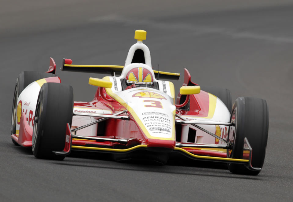 Helio Castroneves, of Brazil, drives through the first turn on his qualification run on the first day of qualifications for the Indianapolis 500 auto race at Indianapolis Motor Speedway in Indianapolis, Saturday, May 18, 2013. (AP Photo/AJ Mast)