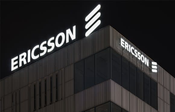 White Ericsson logos on an office building, shot at night.