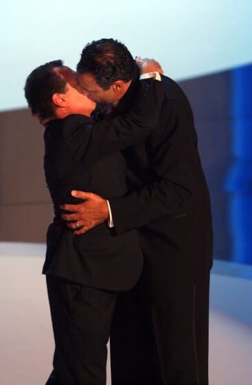 Garry Shandling (L) gets a kiss from Brad Garrett at the 55th annual Emmy Awards at the Shrine Auditorium