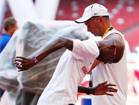 Mo Farah of Great Britain jobs past coach Alberto Salazar in the Bird's Nest Stadium at the Wold Athletics Championships in Beijing, China, August 21, 2015. REUTERS/Lucy Nicholson/Files