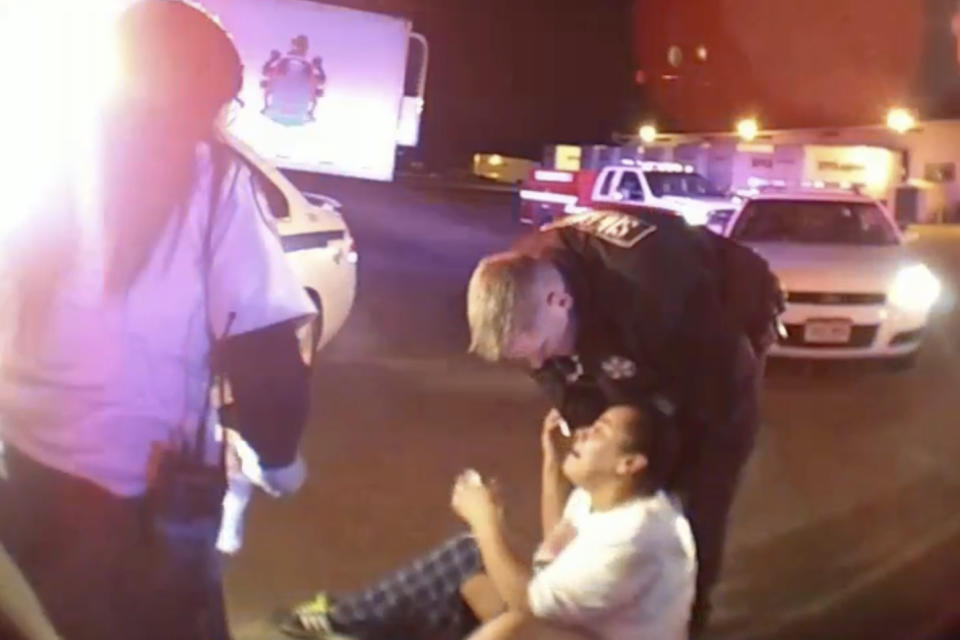 In this image from El Paso County Sheriff's Office body-camera video, a deputy approaches a distraught Jerica LaCour in Colorado Springs, Colo., on Jan. 11, 2018. She was stressed about family finances, husband Anthony LaCour recalled, when deputies found her trespassing at a trucking company. (El Paso County Sheriff's Office via AP)