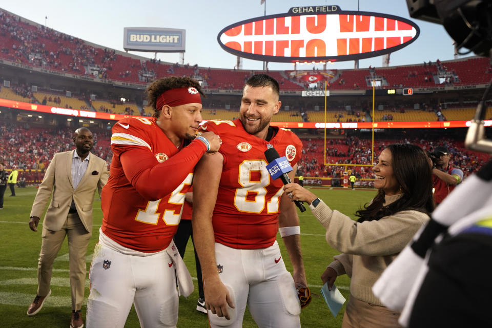 Kansas City Chiefs' Travis Kelce (87) is congratulated by teammate Patrick Mahomes (15) while being interviewed following an NFL football game against the Los Angeles Chargers Sunday, Oct. 22, 2023, in Kansas City, Mo. The Chiefs won 31-17. (AP Photo/Ed Zurga)