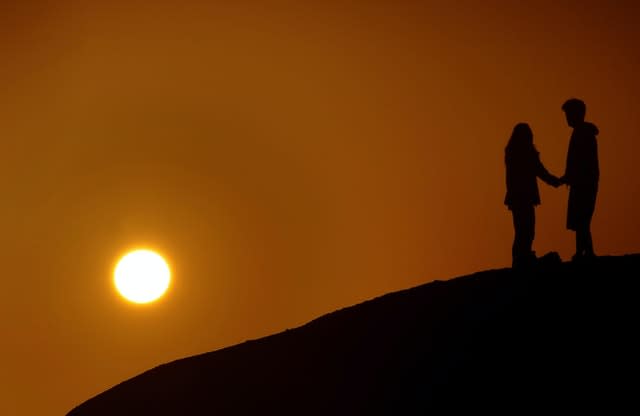 A couple hold hands  (Anthony Devlin/PA)