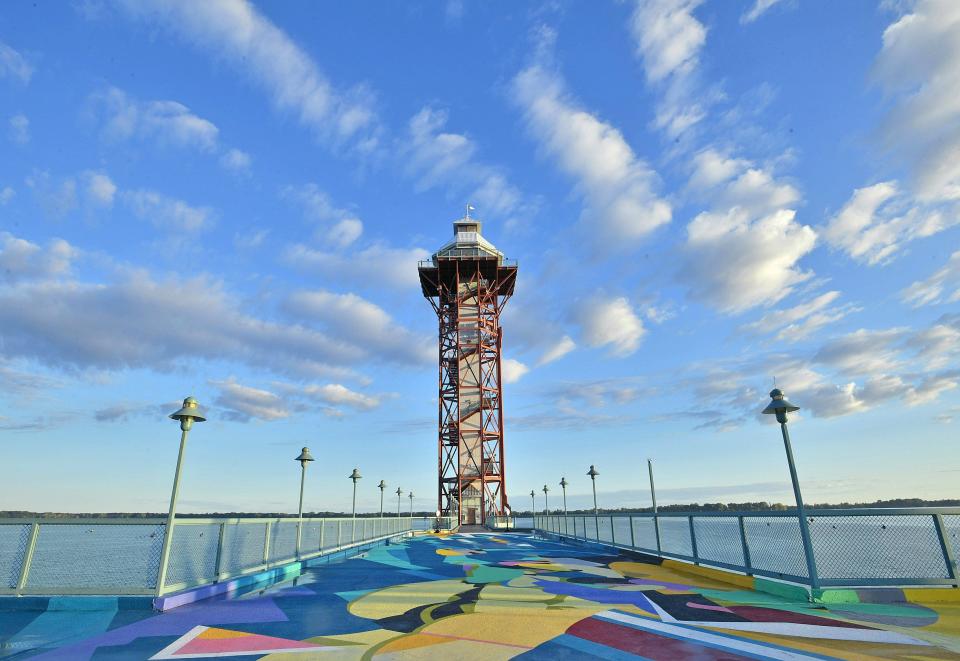 The Bicentennial Tower, an iconic Erie landmark, is shown, Aug. 18, 2020, at Dobbins Landing on Erie's bayfront. In the background is Presque Isle Bay. The artwork on in the foreground on the south side of the tower platform is titled "Flotsam," and was painted in August 2019 by internationally-known artist Rafael Gerlach, known as SatOne.