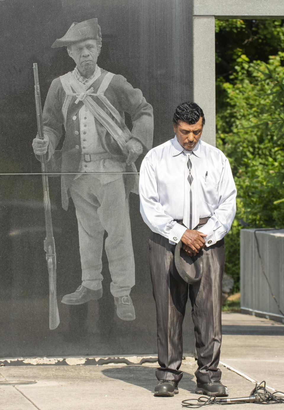Jimmy Winters, president of the local chapter of the NAACP, stands in front of a monument dedicated to The Black Regiment at Patriots Park in Portsmouth during a previous ceremony.