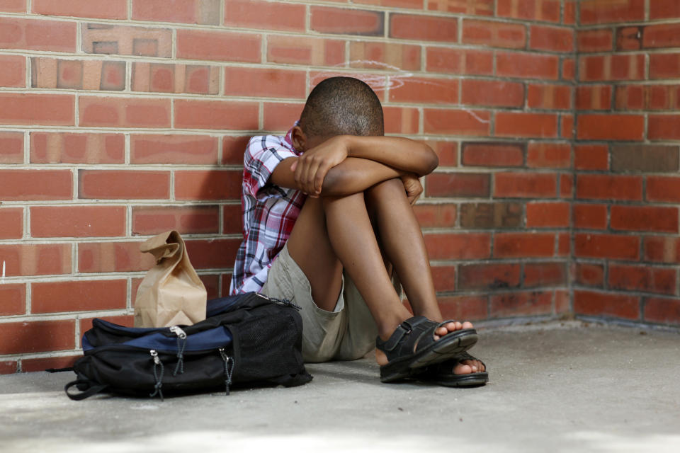 young student resting their head in their knees