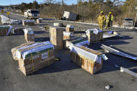 Crates holding live monkeys are scattered across the westbound lanes of state Route 54 at the junction with Interstate 80 near Danville, Pa., Friday, Jan. 21, 2022, after a pickup pulling a trailer carrying the monkeys was hit by a dump truck. They were transporting 100 monkeys and several were on the loose at the time of the photo. (Jimmy May/Bloomsburg Press Enterprise via AP)