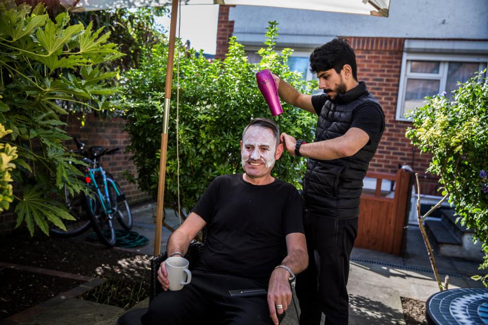 <p>Syrian refugee Lutfi Al-Shaabin, who worked as a barber in Jordan where his family lived as refugees, cuts Tim Finch's hair at the Al-Shaabin home in south London</p>Andrew McConnel