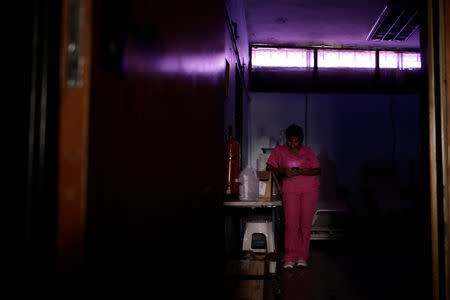 FILE PHOTO: A nurse uses a mobile phone while she waits for the electricity to return in a dialysis centre, during a blackout in Maracaibo, Venezuela, April 11, 2019. REUTERS/Ueslei Marcelino
