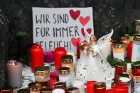 People pay their respects near the site where a car crashed into pedestrians in Trier