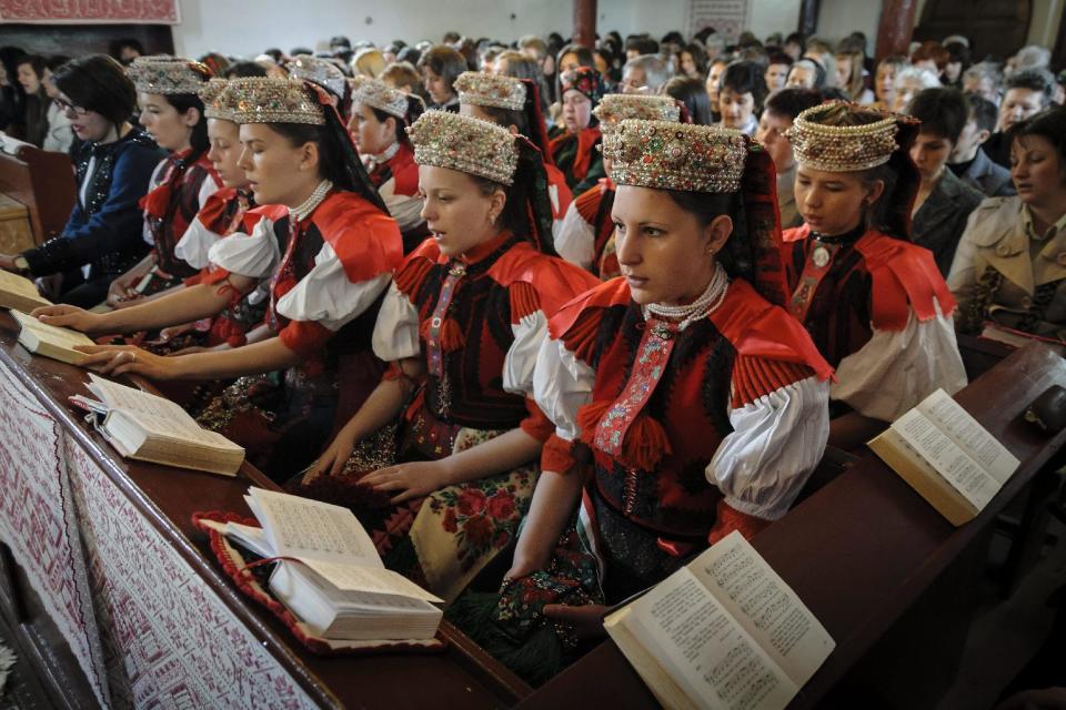 Ethnic Hungarian girls wearing traditional folk costumes attend the Easter service in the Reformed church of the village of Sancraiu, Transylvania, North Western Romania, Sunday, April 20, 2014. (AP Photo/MTI, Zsolt Czegledi)