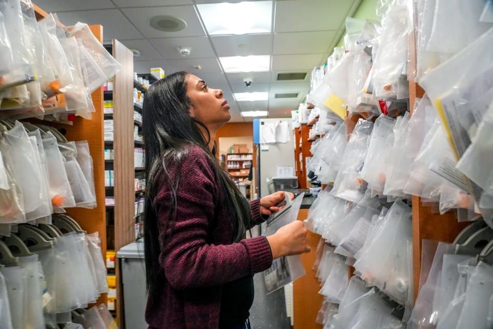 Technician Desiree Guzman works the counter at Lifespan's inhouse pharmacy.