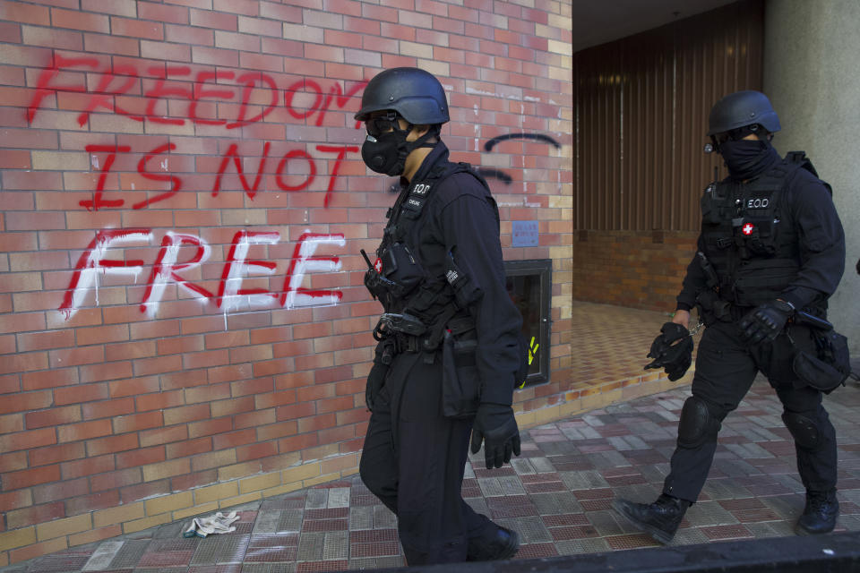 Policemen from Explosive Ordnance Disposal (EOD) unit search for dangerous materials at the Hong Kong Polytechnic University campus in Hong Kong, Thursday, Nov. 28, 2019. Police safety teams Thursday began clearing a university that was a flashpoint for clashes with protesters, and an officer said any holdouts still hiding inside would not be immediately arrested. (AP Photo/Ng Han Guan)