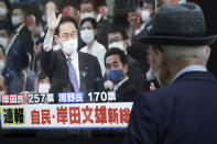 A pedestrian looks at a public TV showing Fumio Kishida, former foreign minister, with a live broadcast of the Liberal Democratic Party (LDP}'s presidential election Wednesday, Sept. 29, 2021, in Tokyo. Kishida has won the governing party leadership election and is set to become the next prime minister. The Japanese letters read: "Fumio Kishida new LDP president." (AP Photo/Eugene Hoshiko)