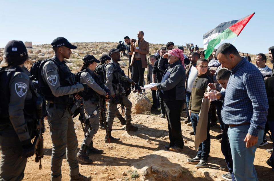 <div class="inline-image__caption"><p>A Palestinian shows papers during a protest against settlements in Masafer Yatta near Hebron, in the Israeli-occupied West Bank, Jan. 20, 2023.</p></div> <div class="inline-image__credit">Mussa Qawasma/Reuters</div>