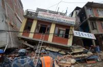 Rescue personnel observe damaged buildings following an earthquake in Kathmandu on April 26, 2015