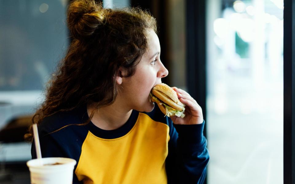 Girl eating hamburger - Alamy