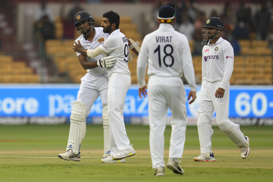 India's Jasprit Bumrah, second left, greets Sri Lanka's Suranga Lakmal after taking his wicket during the third day of the second cricket test match between India and Sri Lanka in Bengaluru, India, Monday, March 14, 2022. (AP Photo/Aijaz Rahi)