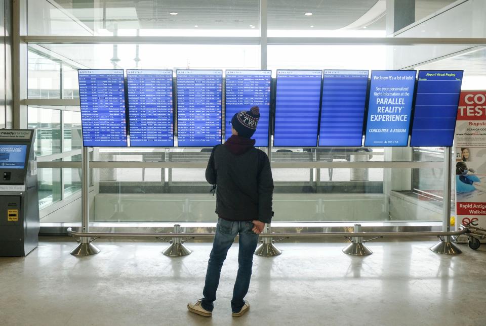 A traveler looks at flight status boards in on December 24, 2022 in Detroit, Michigan. (Photo by Matthew Hatcher/Getty Images)